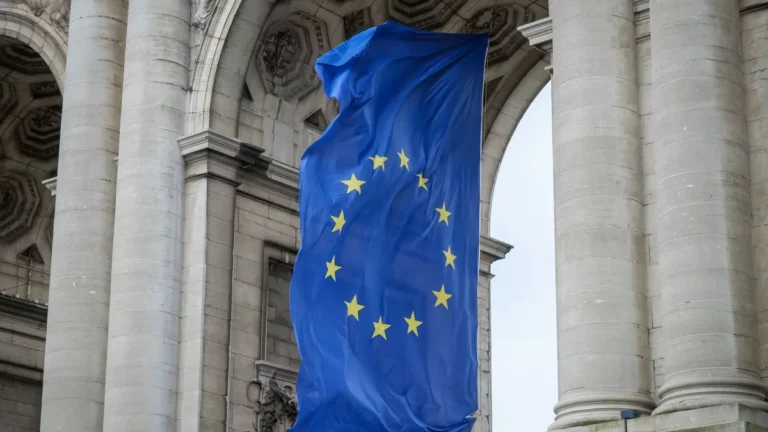 Flaga Unii Europejskiej przed kamienną arkadą