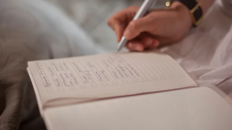 Ręka wypisująca listę kontrolną w notesie